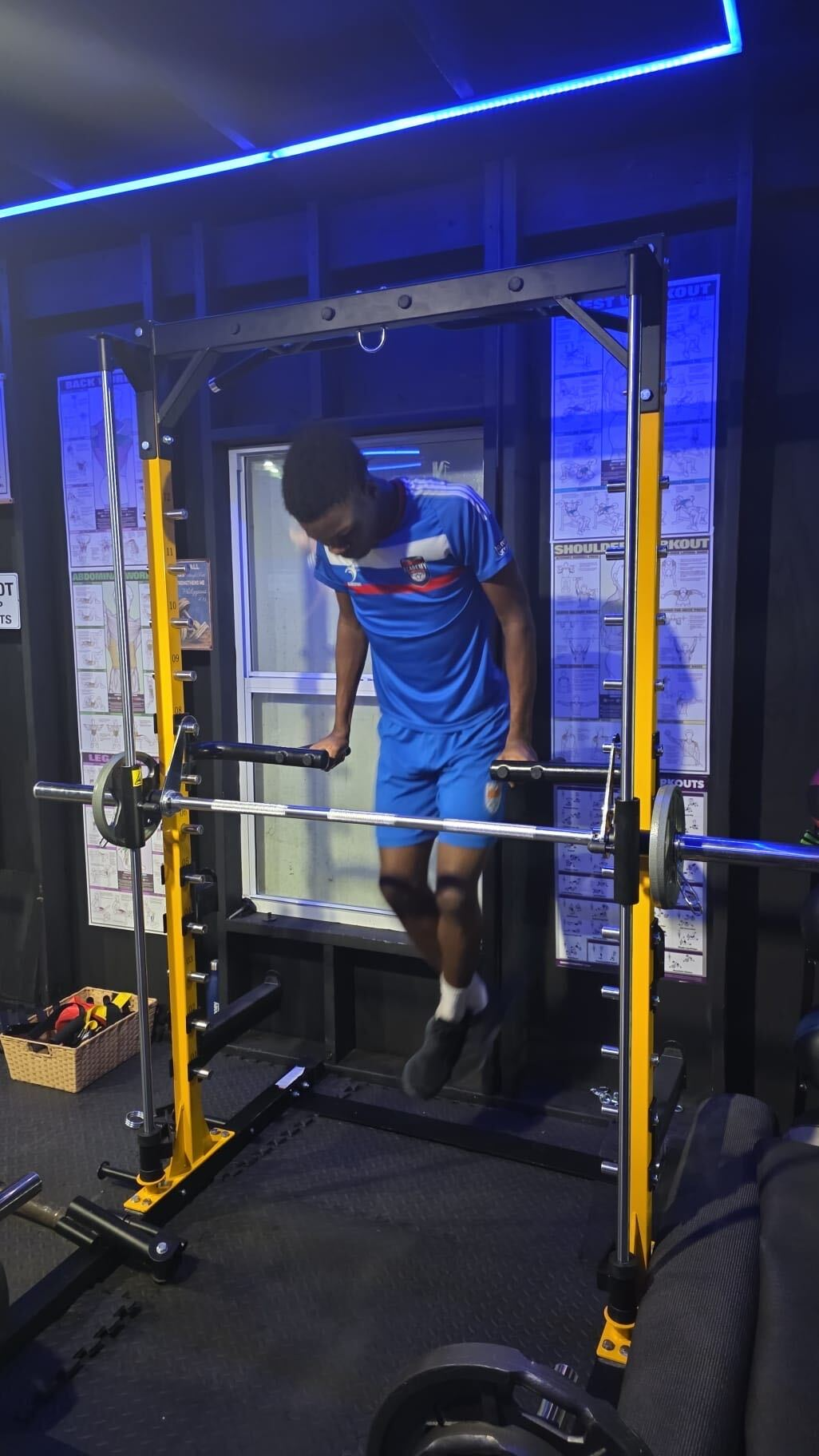A footballer using strength-training equipment at Academy Sports Club.