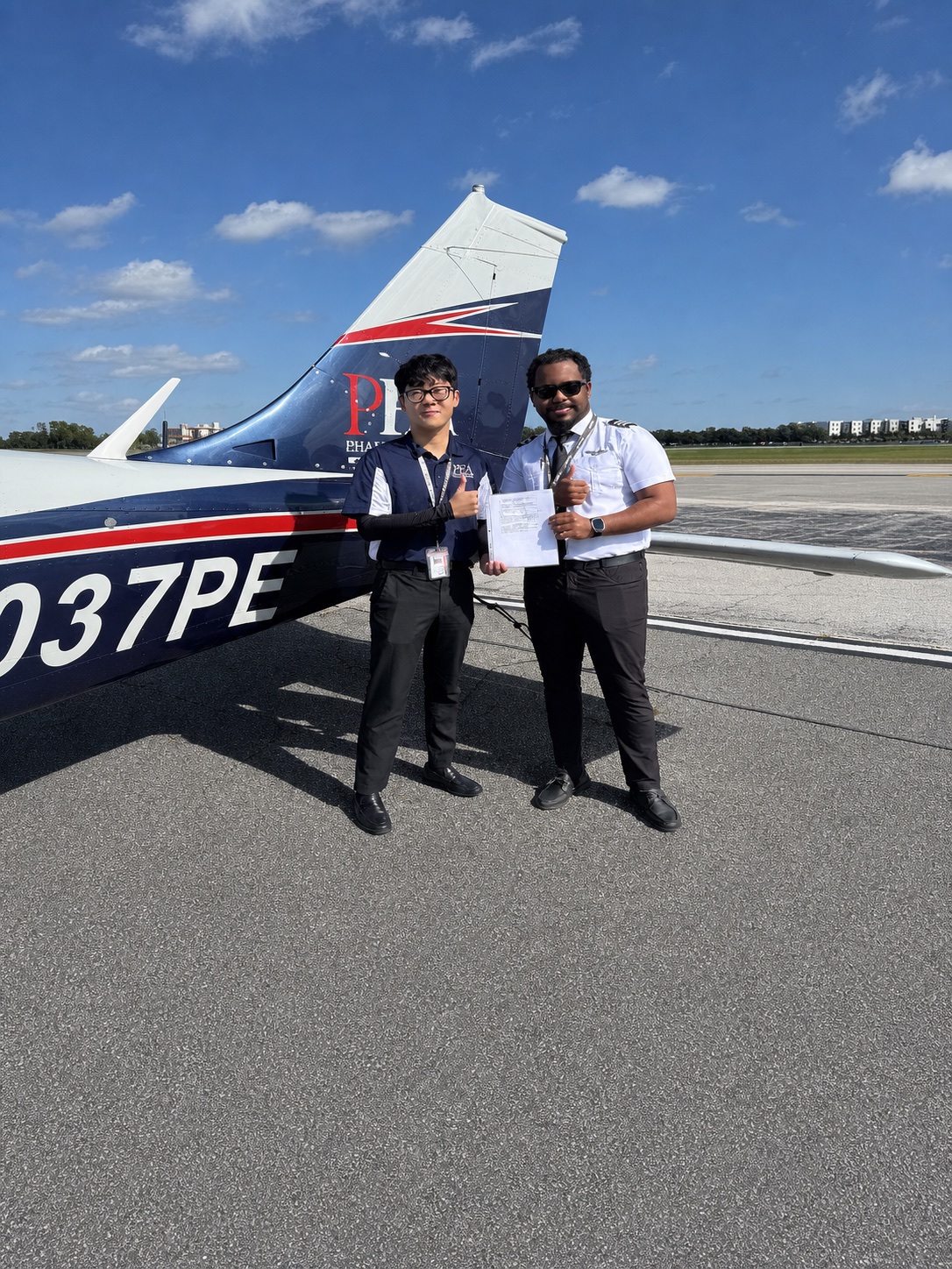 Rashon Connor with a representative beside a training aircraft.